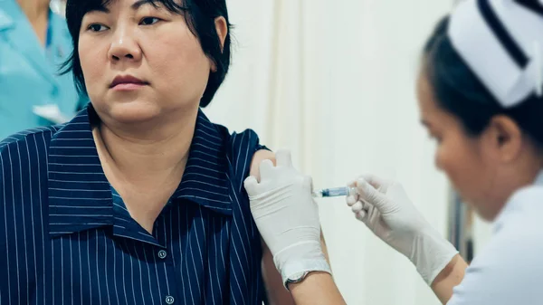 Asian woman health check by get vaccinated against the flu every year by the Ministry of Health.