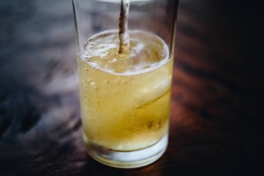 Bira cam buz ile soğuk bira su ve köpük brewery pub ya da ahşap bir masa üzerine Restoran yılında bira döküyor