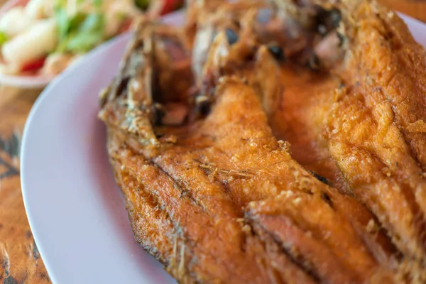 Peixe frito com molho de peixe no mercado tailandês de frutos do mar — Fotografia de Stock