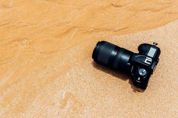 DSLR camera on beach wet from water sea wave — Stock Photo, Image