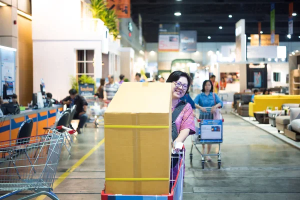 Asian woman with shopping cart in department store