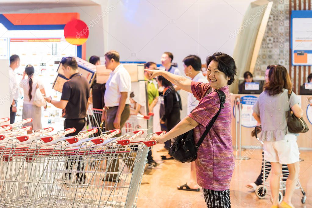 Asian woman with shopping cart in department store