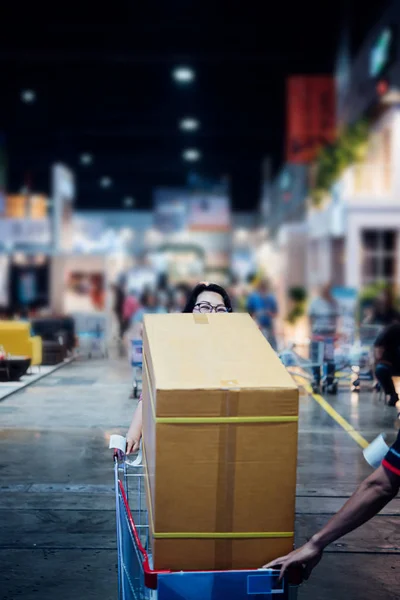 Asian woman with shopping cart in department store