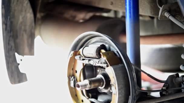 汽车修理工或军人检查鼓式制动器和石棉刹车片这是汽车使用的一部分 用于停止汽车后轮的安全这一新的备件维修在汽车修理厂 — 图库视频影像