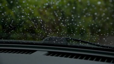 Su damlası yağmur arabanın içinde araba ön cam görünümü temizlemek için araba silecek çalışma