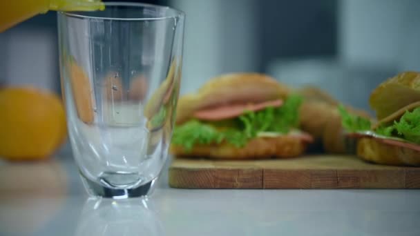 Öntés Friss Narancslé Vizet Üveg Homályos Croissant Sonka Szendvics Fedélzeten — Stock videók