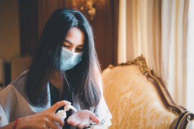 Maske takan Asyalı kadın ve alkol antibakteriyel el jel solunum koruyucu maskesi salgın gribe karşı covid19 ya da Corona virüsüne karşı konsept hastalıkları, salgın hastalıklar, sağlık hizmetleri gibi korkuları olan
