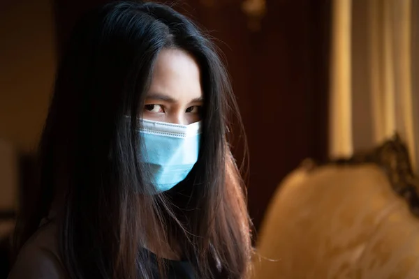 Asian pretty woman wearing mask respiratory protection mask against epidemic flu covid19 or corona virus influenza in office with fear emotion in concept illness, outbreak, healthcare in life