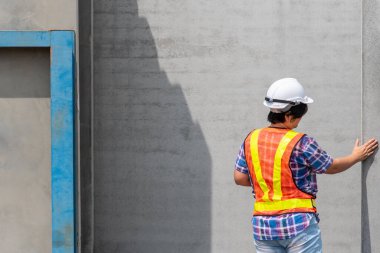 İnşaat mühendisi Asyalı kadın miğfer ve güvenlik yeleği olan mimar ya da mühendis bina ya da şantiyede çalışmaktan mutlu.
