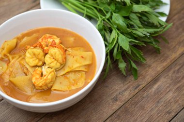Tayland baharatlı baharatlı, karides ve karidesli sarı köri ve sebzelerle yenmiş bambu filizi (Gaaeng Leuang) veya Tayland restoranında satılık Oenanthe.