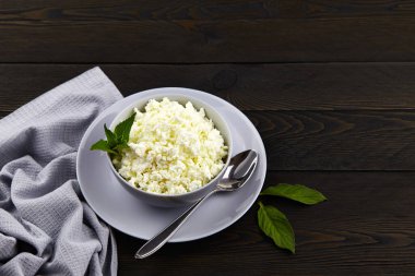 Tahta masada, kasede taze, doğal süzme peynir. Organik süt ürünleri ile sağlıklı gıda kavramı.