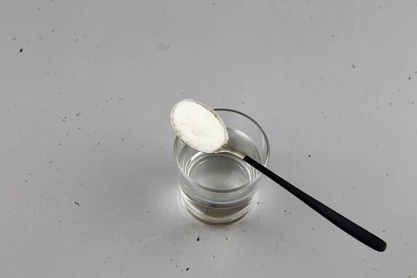 Πρωτεΐνη Κολλαγόνου Σκόνη Στο Κουτάλι Και Ένα Ποτήρι Νερό Γκρι — Φωτογραφία Αρχείου