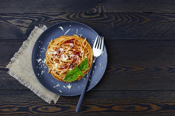 经典的意大利面食 番茄酱 意大利面和罗勒在盘子上的深色木制背景 顶部视图 复制空间 — 图库照片
