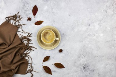 Sonbahar kompozisyonu. Sütlü kahve, sonbahar yaprakları ve gri arka planda ekose. Düz yatış, üst görünüm.