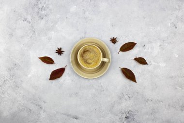 Sonbahar kompozisyonu. Sütlü kahve, gri arka planda sonbahar yaprakları. Düz yatış, üst görünüm.