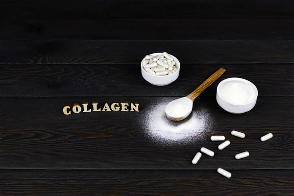 Kolajen protein tozu kaşıkta, kolajen kapsülleri kavanozda, tahta arka planda. Cilt ve eklemler için beslenme desteği.