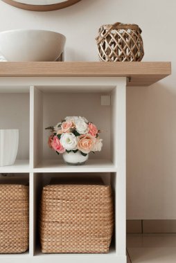 Banyo içinde yapay çiçekler var. Yuvarlak vazoda dekoratif çiçekler. Yuvarlak vazodaki yapay çiçekler. Banyo içi beyaz. Dekoratif çiçekler. 