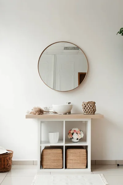 Banyo içinde yapay çiçekler var. Yuvarlak vazoda dekoratif çiçekler. Yuvarlak vazodaki yapay çiçekler. Banyo içi beyaz. Dekoratif çiçekler. 