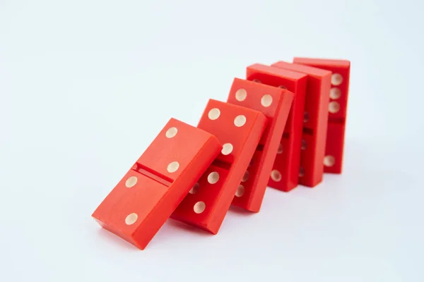 Dominoes on plain background, about to fall