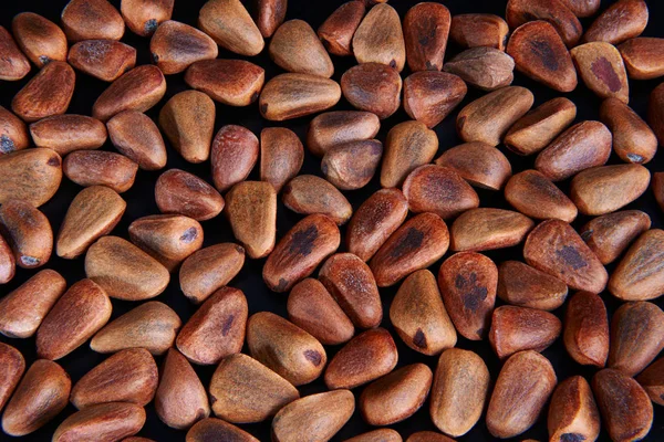pine nuts on a black background