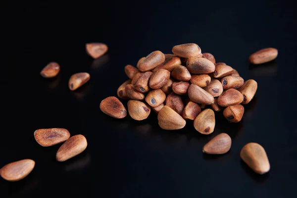 pine nuts on a black background