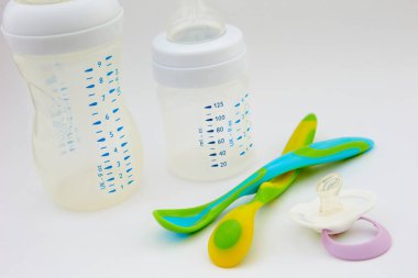 Biberon ve meme ucu beyaz zemin üzerinde. renkli bebek kaşık