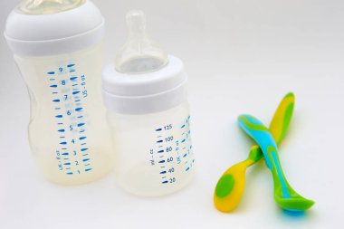 Biberon ve meme ucu beyaz zemin üzerinde. renkli bebek kaşık