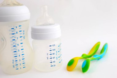 Biberon ve meme ucu beyaz zemin üzerinde. renkli bebek kaşık