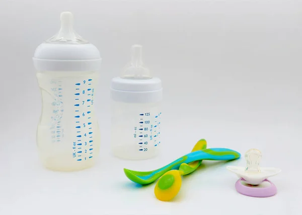 Biberon ve meme ucu beyaz zemin üzerinde. renkli bebek kaşık