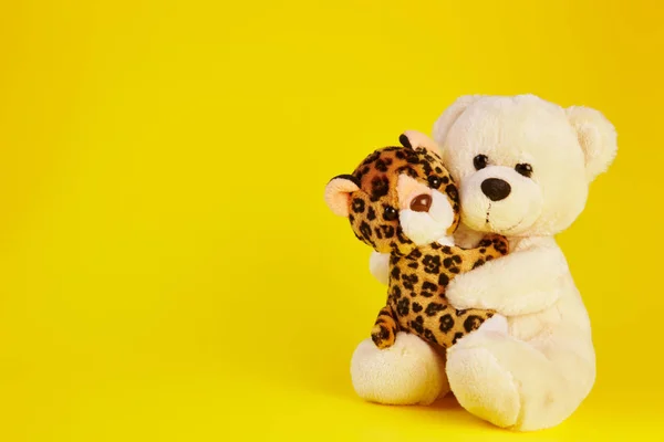 toy bear and a toy leopard with a yellow background