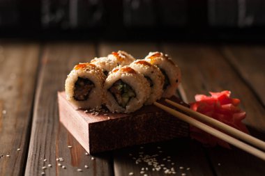 Havyar ve salatalık ile ahşap plaka üzerinde beyaz pirinç ile beyaz suşi rulo