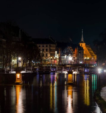 Yansımaları Nehri'nde hasta, Fransa ile Saint Nicolas church civarındaki Strasbourg gece görünümü