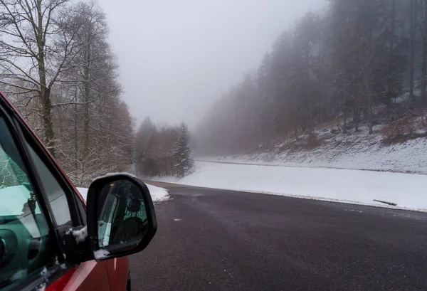 Carro vermelho na estrada de inverno nas montanhas, floresta com neve — Fotografia de Stock