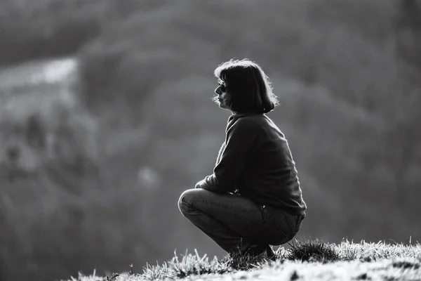 Silueta de mujer. Sentado en la colina. Relajación y tranquilidad . — Foto de Stock