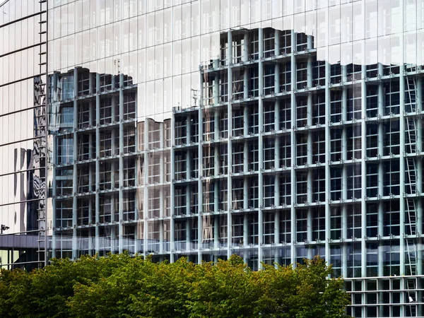 O edifício moderno de vidro e aço. Reflexões em um copo — Fotografia de Stock