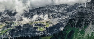 Korkunç cansız kayalar, Alpler 'de bir buzul, dağların zirvelerine yayılmış bulutlar ve sis. İsviçre
