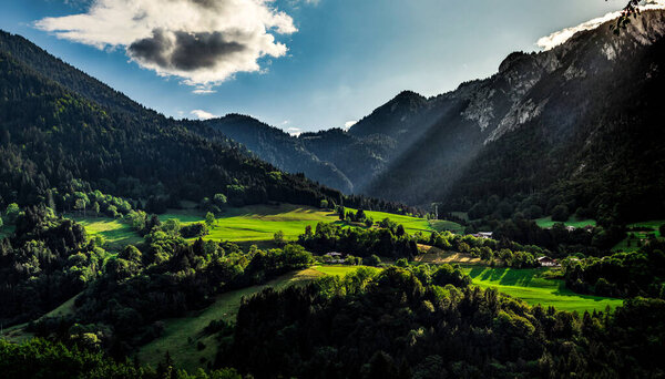 Panoramic view of alpine meadows and rocks in sunset evening lighting, Alps