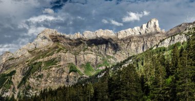Korkunç cansız kayalar, Alpler 'de bir buzul, dağların zirvelerine yayılmış bulutlar ve sis. İsviçre