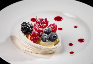 Böğürtlenli lezzetli pasta: kırmızı frenk üzümü, yabanmersini, böğürtlen. Kremalı ve güzel şekilli. Lokantada tatlı var. Yiyecekler. Siyah arkaplanda izole.