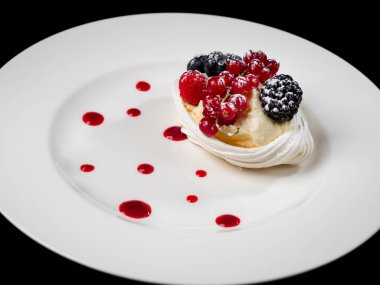 Böğürtlenli lezzetli pasta: kırmızı frenk üzümü, yabanmersini, böğürtlen. Kremalı ve güzel şekilli. Lokantada tatlı var. Yiyecekler. Siyah arkaplanda izole.