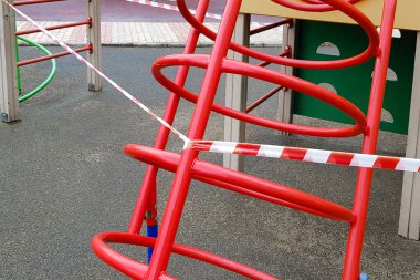 Oyun parkındaki çocuk spor metal yapısı kırmızı bant ile sarılmış. Dışarıda yürüyüş yasağı, koronavirüs gribi virüsünün biyolojik tehlikesinin önlenmesi covid-19. Girdi yok.