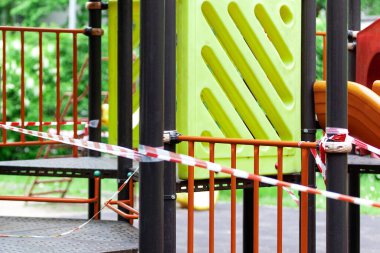Küçük çocuklar için oyun parkı kırmızı bariyerlerle sarılı. Dışarı çıkın. Açık havada yürüyüş yasağı, Coronavirus gribi virüsünün önlenmesi covid-19. Sağlık ve ilaç. seçici odak