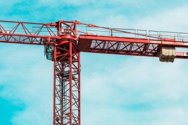 Kırmızı kule vinci yatay pozisyonda. Beyaz bulutlu turkuaz gökyüzüne karşı oklar. Kapatın. Uzayı kopyala arkaplan