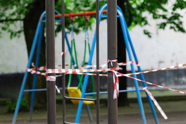 Küçük çocuklar için eğlence ve spor parkı kırmızı bariyer bandına sarılmış durumda. Dışarı çıkın. Açık havada yürüyüş yasağı, Coronavirus gribi virüsünün önlenmesi covid-19.