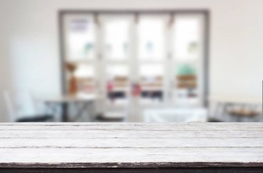 Seçilen odak boş kahverengi ahşap masa ve kafeterya bokeh görüntü ile arka plan bulanıklık. Fotomontaj veya ürün ekran.