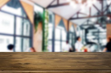 Seçilen odak boş kahverengi ahşap masa ve kafeterya bokeh görüntü ile arka plan bulanıklık. Fotomontaj veya ürün ekran.