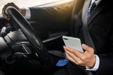 Çekici genç iş adamı. Arabada cep telefonu kullanıyor..