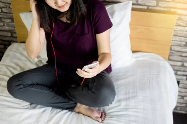 Νεαρή Γυναίκα Κάθεται Στο Κρεβάτι Της Και Ακούει Μουσική Στο — Φωτογραφία Αρχείου