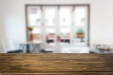 Seçilen odak boş kahverengi ahşap masa ve kafeterya bokeh görüntü ile arka plan bulanıklık. Fotomontaj veya ürün ekran.