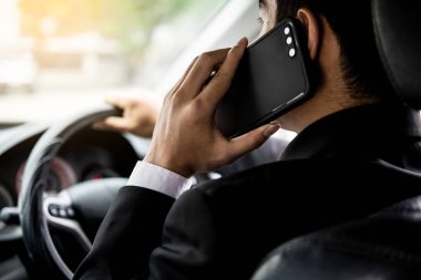 Çekici genç iş adamı. Arabada cep telefonu kullanıyor..